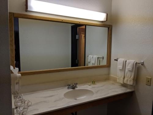 een badkamer met een wastafel en een grote spiegel bij Boarders Inn and Suites by Cobblestone Hotels - Ripon in Ripon