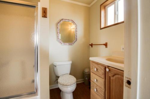 a bathroom with a toilet and a sink and a mirror at Sitka Sky in Oceanside