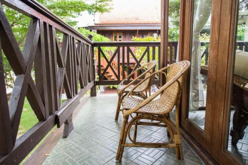 two chairs sitting on a porch with a balcony at Phuttal Residence in Phra Nakhon Si Ayutthaya