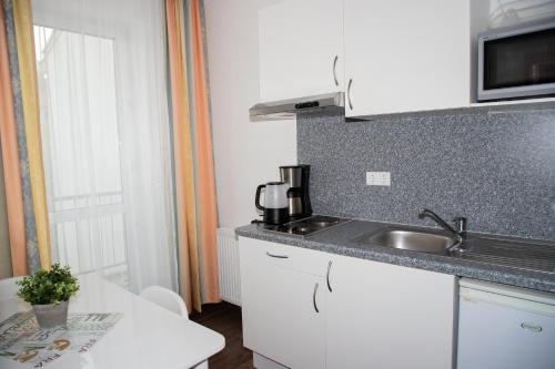 a kitchen with a sink and a counter top at Ferienwohnungen an der Weser in Bremerhaven