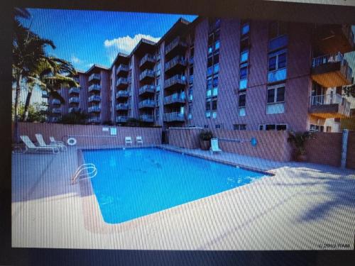 a swimming pool in front of a large building at Nani Kai Hale in Kihei