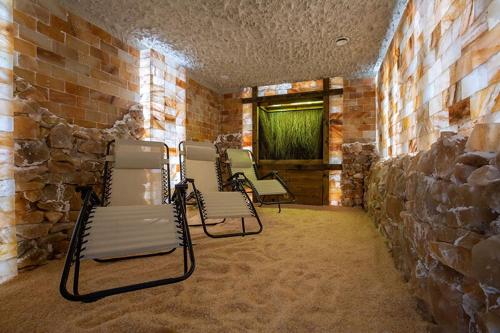 a group of chairs in a room with a stone wall at Jurajski Kryształ in Zaborze