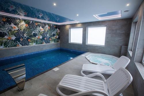 a swimming pool with two chairs and a table and sidx sidx at Jurajski Kryształ in Zaborze
