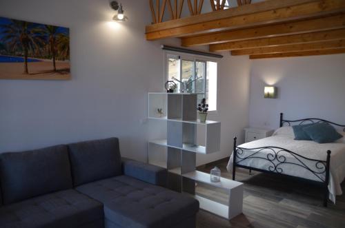 uma sala de estar com um sofá e uma cama em LOFT DE TATO em Jerez de la Frontera