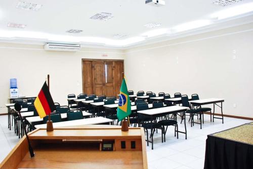 a room with tables and chairs with flags in it at Hotel Dom Otto in Vespasiano