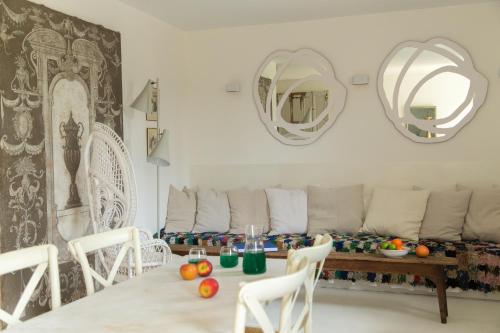 - un salon avec une table, des chaises et des miroirs dans l'établissement Le gîte, à Uzès