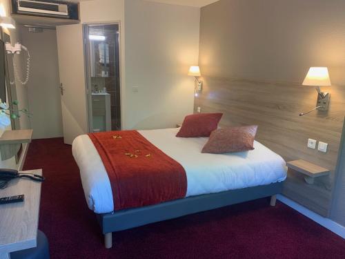 a hotel room with a bed with two pillows at The Originals City, Hôtel Nîmes Costières in Nîmes