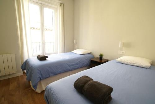 馬德里的住宿－Luxury Apartment in Historic Center，一间卧室设有两张床和窗户。