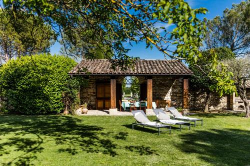 - un groupe de chaises longues blanches dans la cour dans l'établissement Le gîte, à Uzès