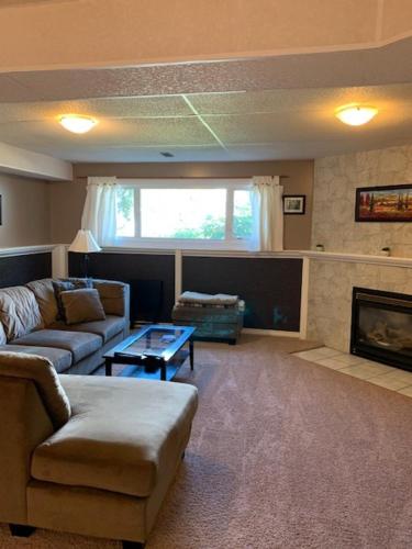 a living room with a couch and a fireplace at Newly Renovated Basement Suite! in Lethbridge