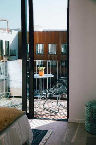 a room with a balcony with a table and a table at Hotel San Luis Obispo in San Luis Obispo