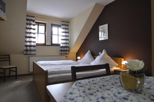 a hotel room with a bed and a table at Landgasthof Lang Zum Adler in Oberkalbach