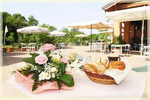 a table with a basket of bread and flowers on it at Country House Country Club in Noghera