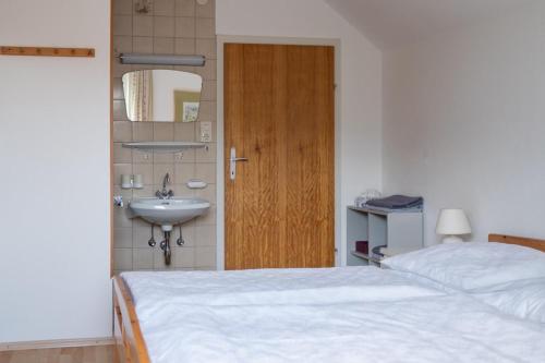 a bedroom with a bed and a sink and a door at Ferienwohnung Meliessnig in Mauterndorf
