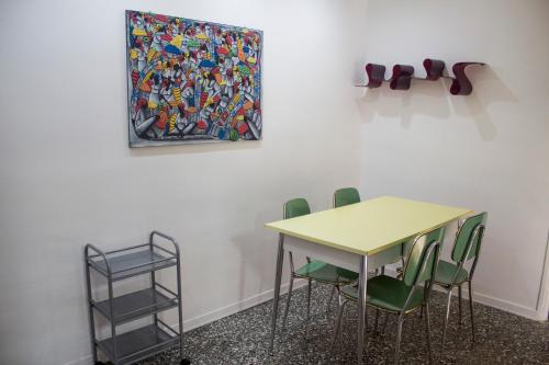a table and chairs with a painting on the wall at Rho-Fiera - Appartamento in antica cascina in Pero