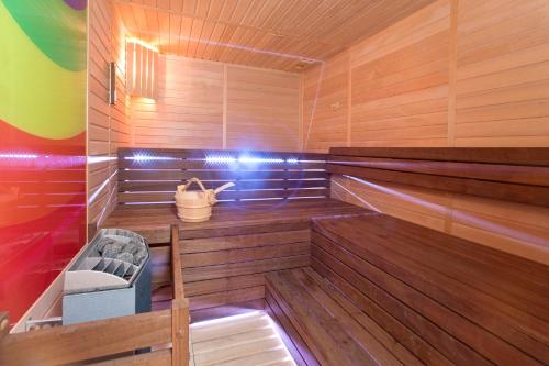 a sauna with wooden walls and wooden floors and a bucket at Hotel Parentium Plava Laguna in Poreč