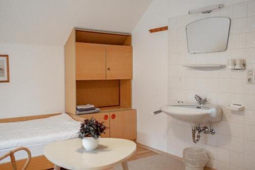 y baño con cama, lavabo y mesa. en Ferienwohnung Meliessnig, en Mauterndorf