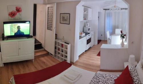 a living room with a flat screen tv and a room with at Gardos in Belgrade