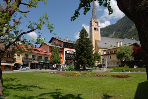 a town with a church with a clock tower at Aurora Appartements inklusive freiem Thermeneintritt in Bad Hofgastein