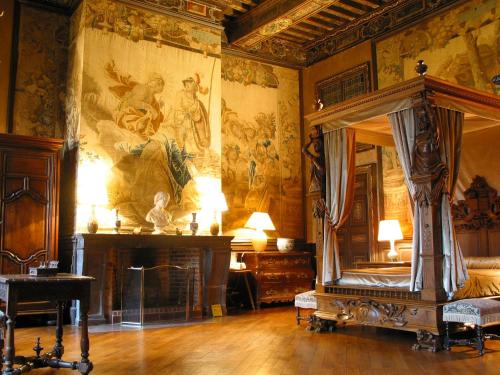 una camera con un letto e un dipinto sul muro di Château de Brissac a Brissac-Quincé