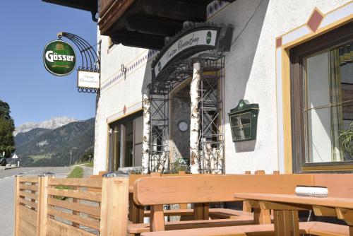 a wooden bench sitting outside of a building at Frühstückspension Oberweissburg in Sankt Michael im Lungau