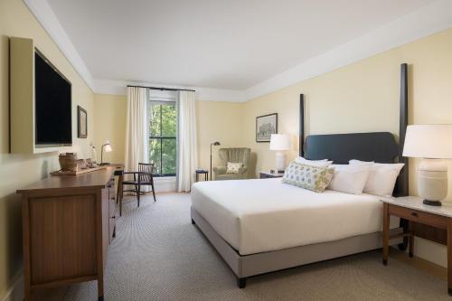 a bedroom with a large white bed and a desk at The Williams Inn in Williamstown