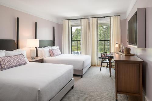 a hotel room with two beds and a desk at The Williams Inn in Williamstown