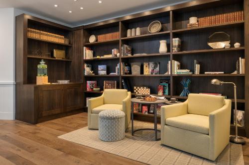 a library with two chairs and shelves with books at The Williams Inn in Williamstown