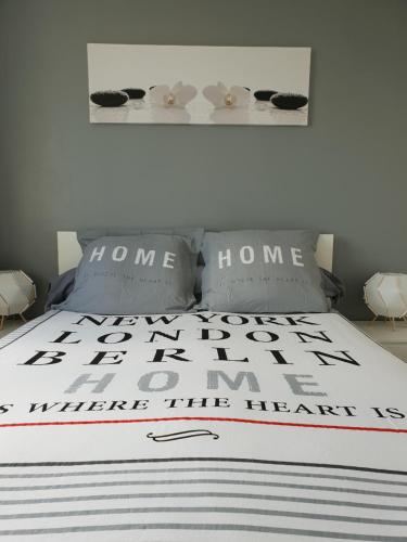 - un lit avec une couette et des oreillers en noir et blanc dans l'établissement T2 Saint martin d'heres proche Campus, à La Tronche