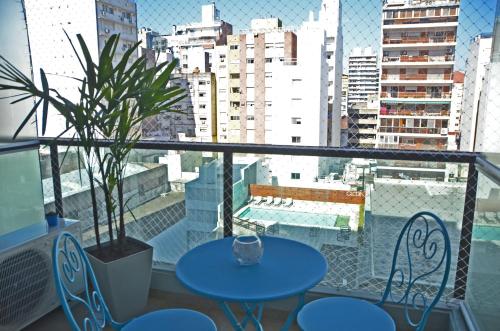 a balcony with two tables and chairs and a potted plant at CDM Temporal in Rosario