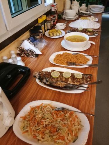 a wooden table with plates of food on it at Galaxy Sunrise Sea View in Fulidhoo