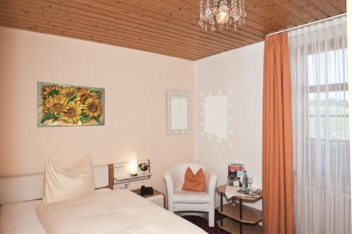 a bedroom with a bed and a table and a chair at Hotel Landgasthof Kranz in Hüfingen