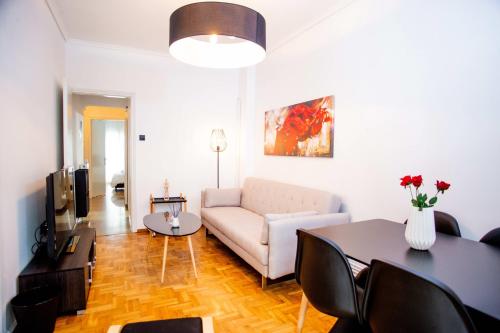 a living room with a couch and a table at Thessaloniki Center Apartment On The Sea in Thessaloniki