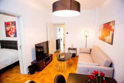 a living room with a couch and a television at Thessaloniki Center Apartment On The Sea in Thessaloniki