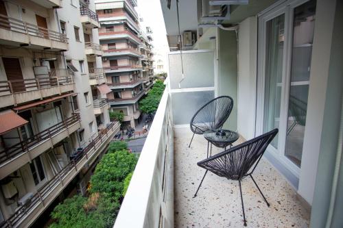 two chairs sitting on the balcony of a building at Thessaloniki Center Apartment On The Sea in Thessaloniki