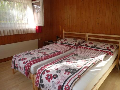 1 Schlafzimmer mit 2 Betten mit roten und weißen Decken in der Unterkunft Wohnung Wohlensee in Hinterkappelen