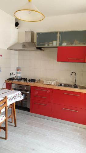 - une cuisine avec des placards rouges et un évier dans l'établissement Appartamento, à Baselga di Pinè
