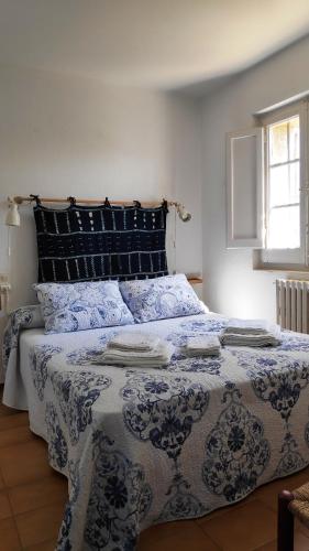 a bedroom with a bed with a blue and white comforter at ÀNCORA VELLA in Sant Antoni de Calonge