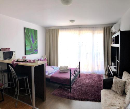 um quarto com uma cama e uma secretária num quarto em Студио Панорама Сънрайз Бяла - кът за отдих и морска почивка em Byala