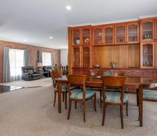 a living room with a wooden table and chairs at Beltie Park Homestead in Wangaratta