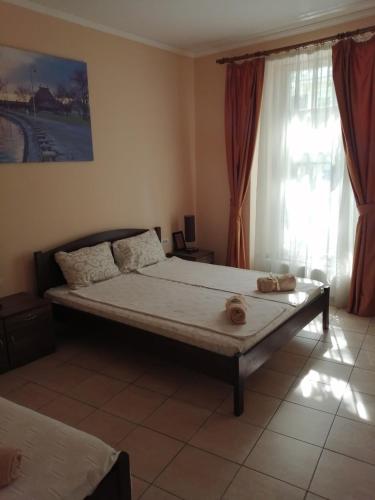 a large bed in a room with a window at Guest House Best Food in Subotica