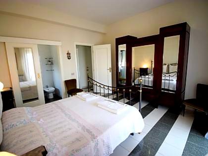 a bedroom with a large bed and a bathroom at Gess Etna Home in Giarre