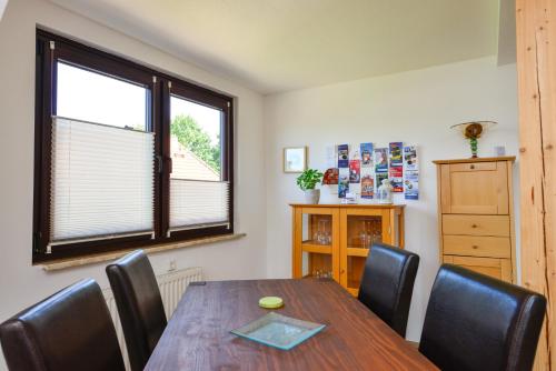 a dining room with a table and chairs and a window at MIA - Ferienwohnung Wehdel bei Bremerhaven in Wehdel