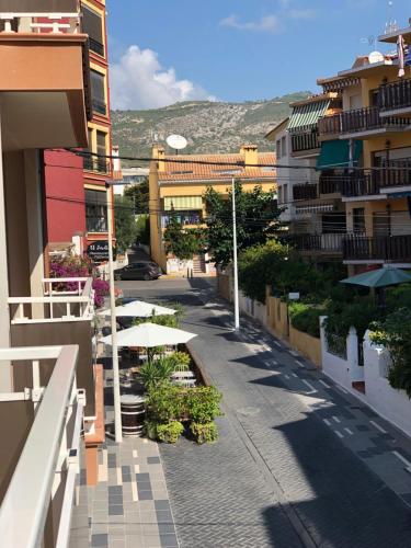 a city street with tables and buildings with a mountain at lovely apartment beside the Alcossebre beach in Alcossebre