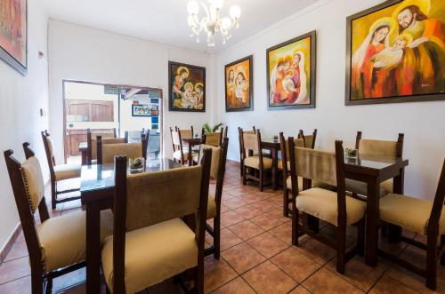 a dining room with tables and chairs and paintings on the walls at Jose Luis Hostal Boutique in Lima
