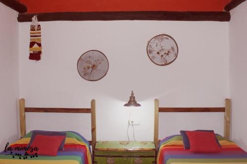 Dos camas en una habitación con dos relojes en la pared en La mimosa, en Carcastillo