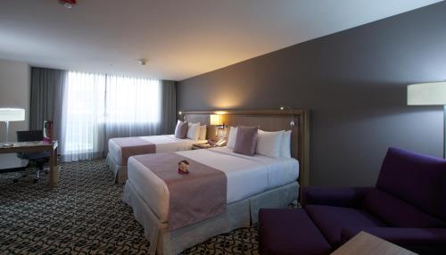 a hotel room with two beds and a couch at Crowne Plaza Hotel Mexico City North-Tlalnepantla by IHG in Mexico City