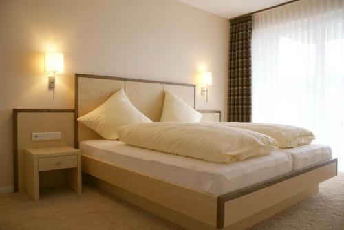 1 dormitorio con 1 cama con sábanas blancas y ventana en Alm Appartements ehemals Birkenhof en Willingen