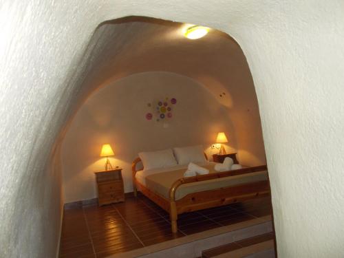 a bedroom with a bed with two lamps on it at Loukas Kontos Traditional House in Emporio