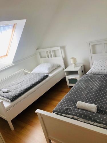 two white beds in a room with a window at Tihany Levendula Villa in Tihany